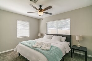 A bedroom with a bed, two bedside lamps, a ceiling fan, and two windows with blinds. - Central Melb Accessible 5bd/3ba Pool-Sleeps 14! (Melbourne)