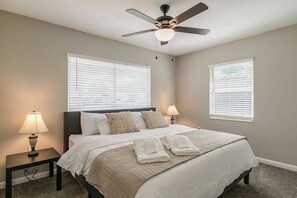 A bedroom with a bed, two bedside tables with lamps, a ceiling fan, and two windows with blinds. - Central Melb Accessible 5bd/3ba Pool-Sleeps 14! (Melbourne)