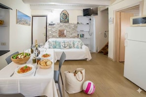 Een kamer met een bed, een eettafel met eten, een televisie en een open haard.
