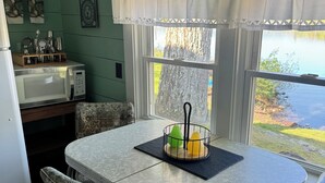 Une cuisine compacte comprenant une table à manger, des chaises, un four à micro-ondes et une fenêtre donnant sur l’extérieur.