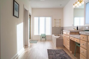 Un baño moderno con bañera, inodoro, lavabo y espejo.