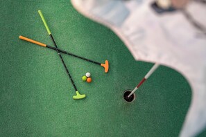 Campo de golf con putting green, birón y pelotas.