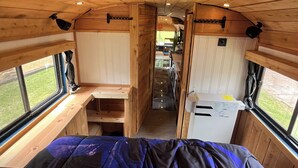 Ein gemütliches Interieur mit einem Bett, Holzwänden und einer Küchenzeile.