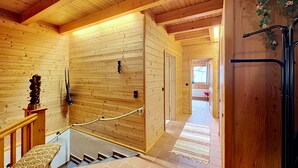 Un interior de madera con una escalera, un banco y una puerta.