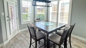 Un espace repas comprenant une table ronde, des chaises et un luminaire suspendu.