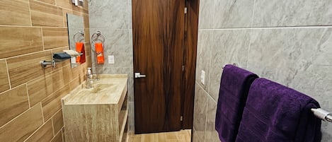 Un baño con inodoro, lavabo y puerta de madera.