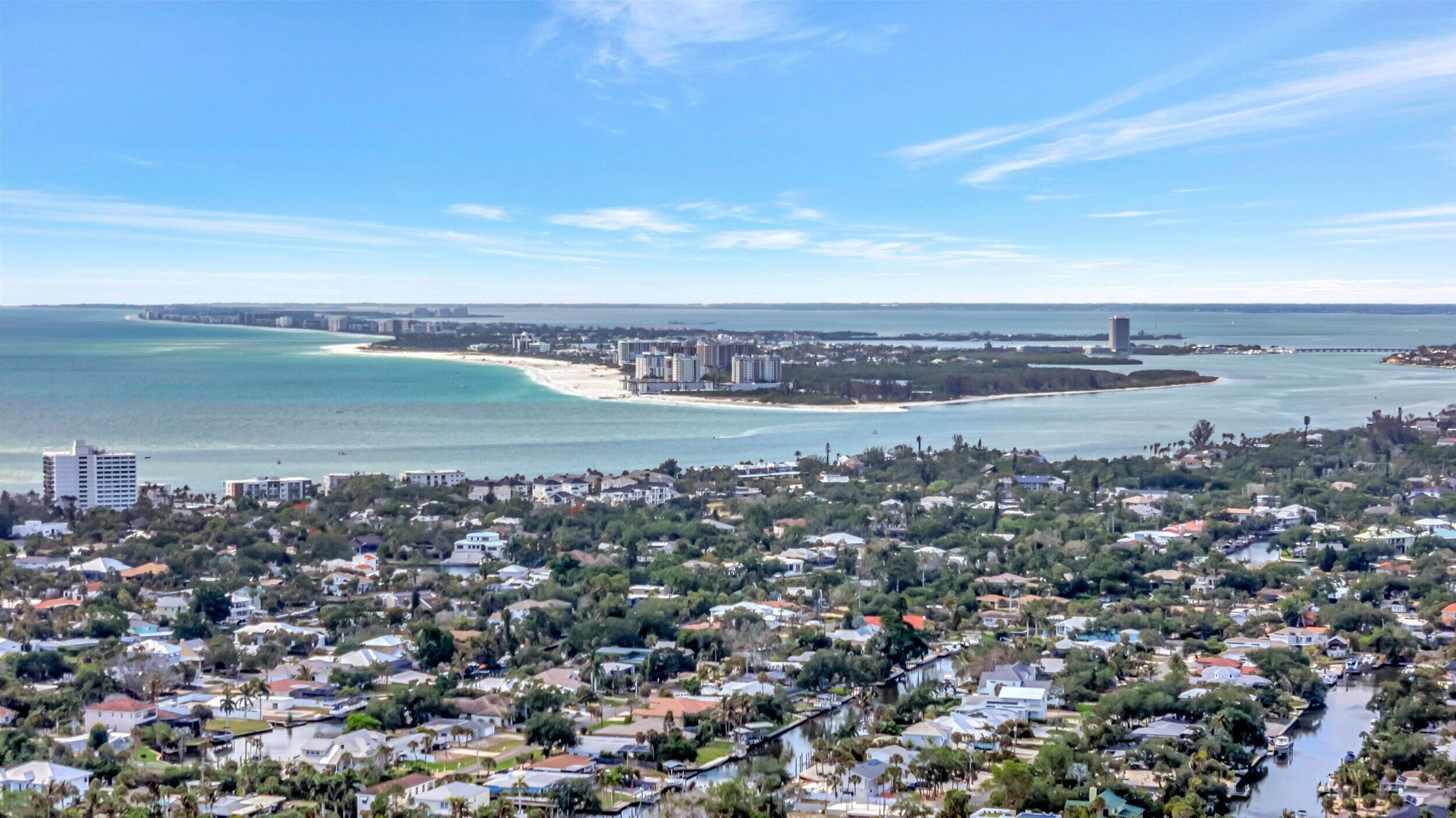 A coastal town with residential buildings, a beach, and a marina.