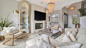 Un salon avec une cheminée, un canapé, une table basse et un téléviseur.