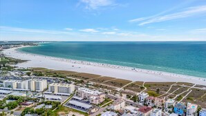 Une zone côtière avec une plage, des bâtiments et un ciel dégagé.