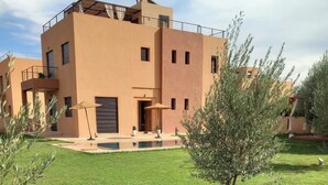 A modern building with a flat roof, a satellite dish, and a small pool area. - Exceptional villa with private pool and 1300m² grounds (Marrakech)
