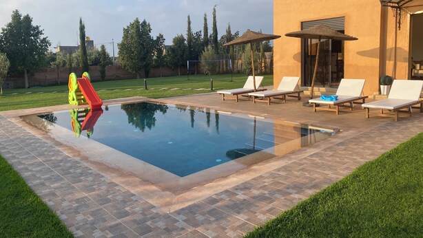 A swimming pool with lounge chairs and a slide. - Exceptional villa with private pool and 1300m² grounds (Marrakech)