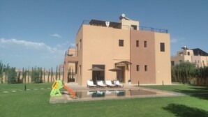 A modern two-story building with a swimming pool, outdoor seating, and a satellite dish. - Exceptional villa with private pool and 1300m² grounds (Marrakech)