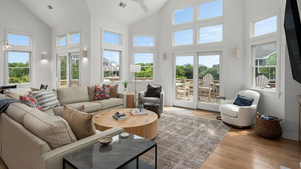 A spacious living room with a large sofa, a coffee table, and a television.