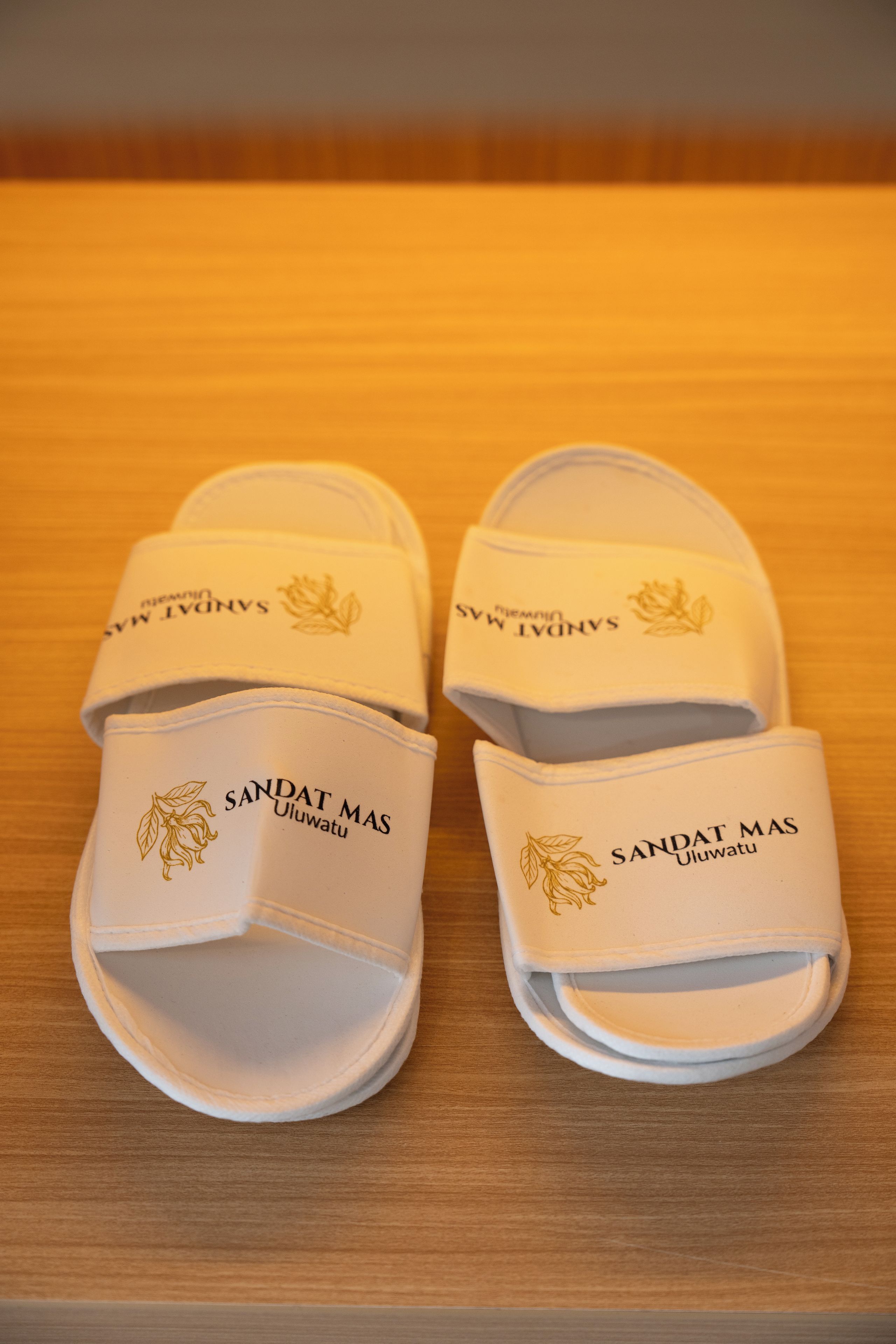 Een paar witte sandalen met de merknaam 'SANDAT MAS' op de band.