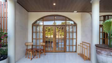 Un espacio de patio cubierto con un banco de madera, una mesa y una planta en maceta.