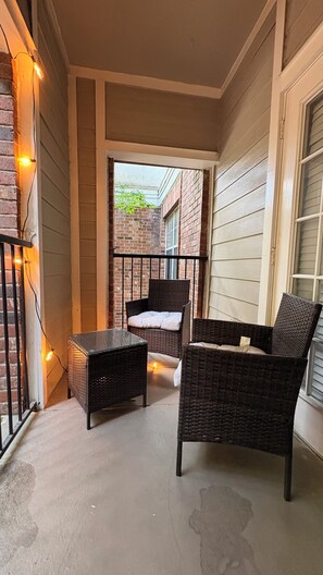 Ein überdachter Patio-Bereich mit Korbmöbeln und Lichterketten.