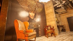 A room with a mural, a wooden chair, and a statue.