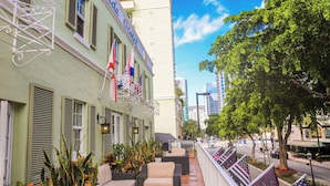 Un hôtel doté d’une terrasse, de drapeaux et offrant une vue sur la rue.