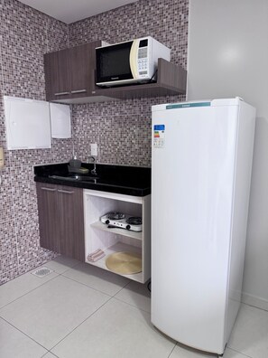 A kitchen with a microwave, a refrigerator, a stove, and a sink.