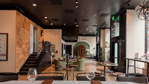 A restaurant interior with a staircase, seating areas, and a bar. - Sentinel | Executive King | Historic Luxury, Curated Art, Wine Lounge (Portland)