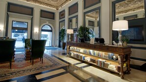 A lobby with a grand ceiling, a reception desk, a bookshelf, and a large window. - Sentinel | Executive King | Historic Luxury, Curated Art, Wine Lounge (Portland)