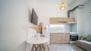 A modern kitchen with wooden cabinets, a built-in oven, and a dining area with a round table and chairs.