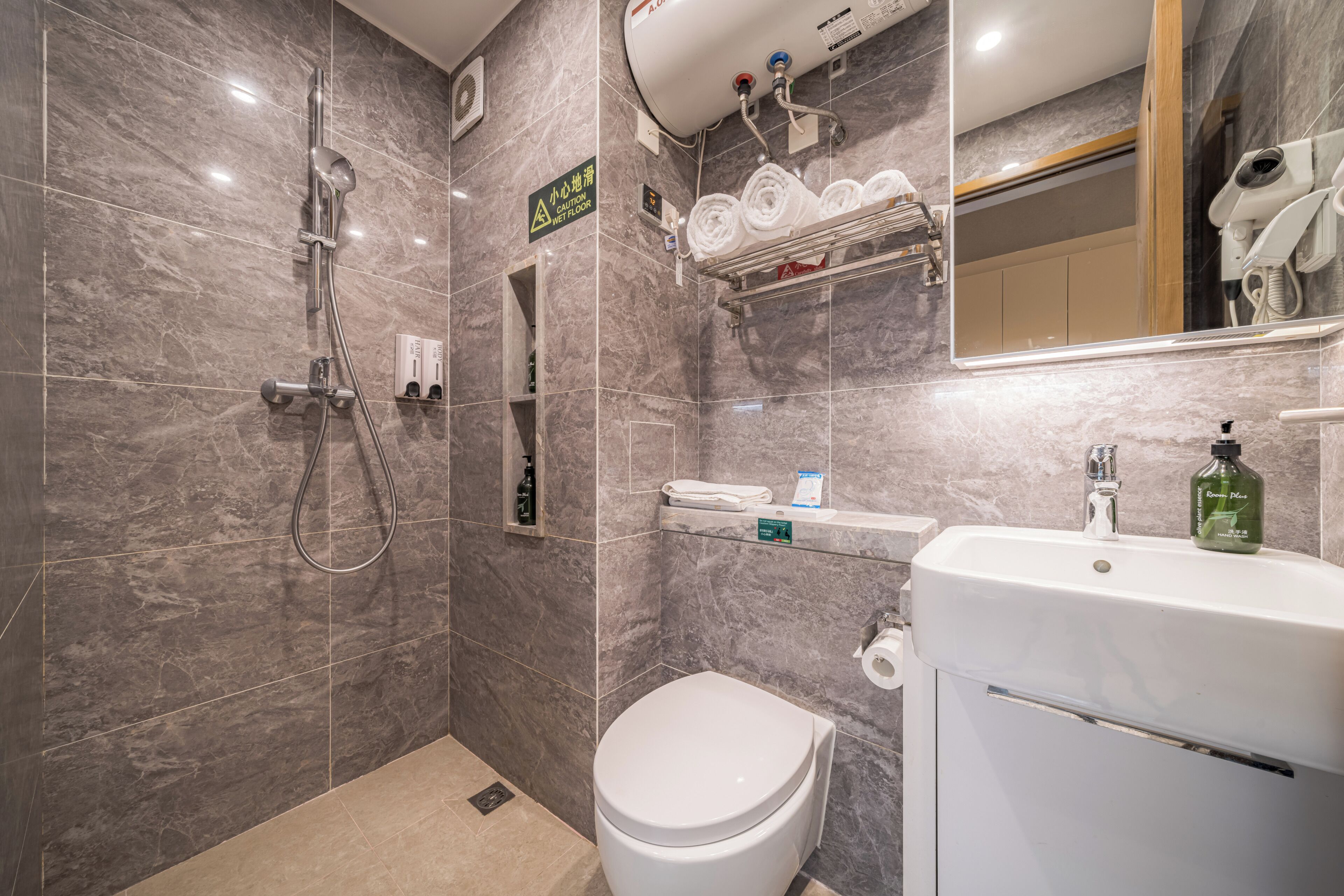 Ein Badezimmer mit Dusche, Toilette, Waschbecken und Handtuchhalter.