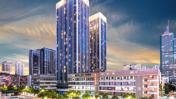 A high-rise building with a modern glass facade, surrounded by other buildings and a clear sky. - Hengbang Times Huaqiang North Store (Shenzhen)