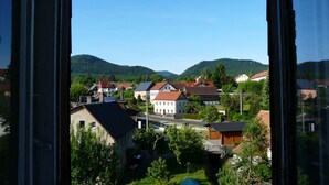 A residential area with houses, a road, and hills in the background.
