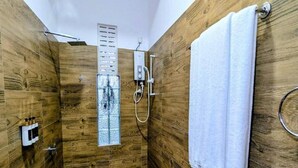 A wooden-paneled shower room with a white towel hanging on the wall.