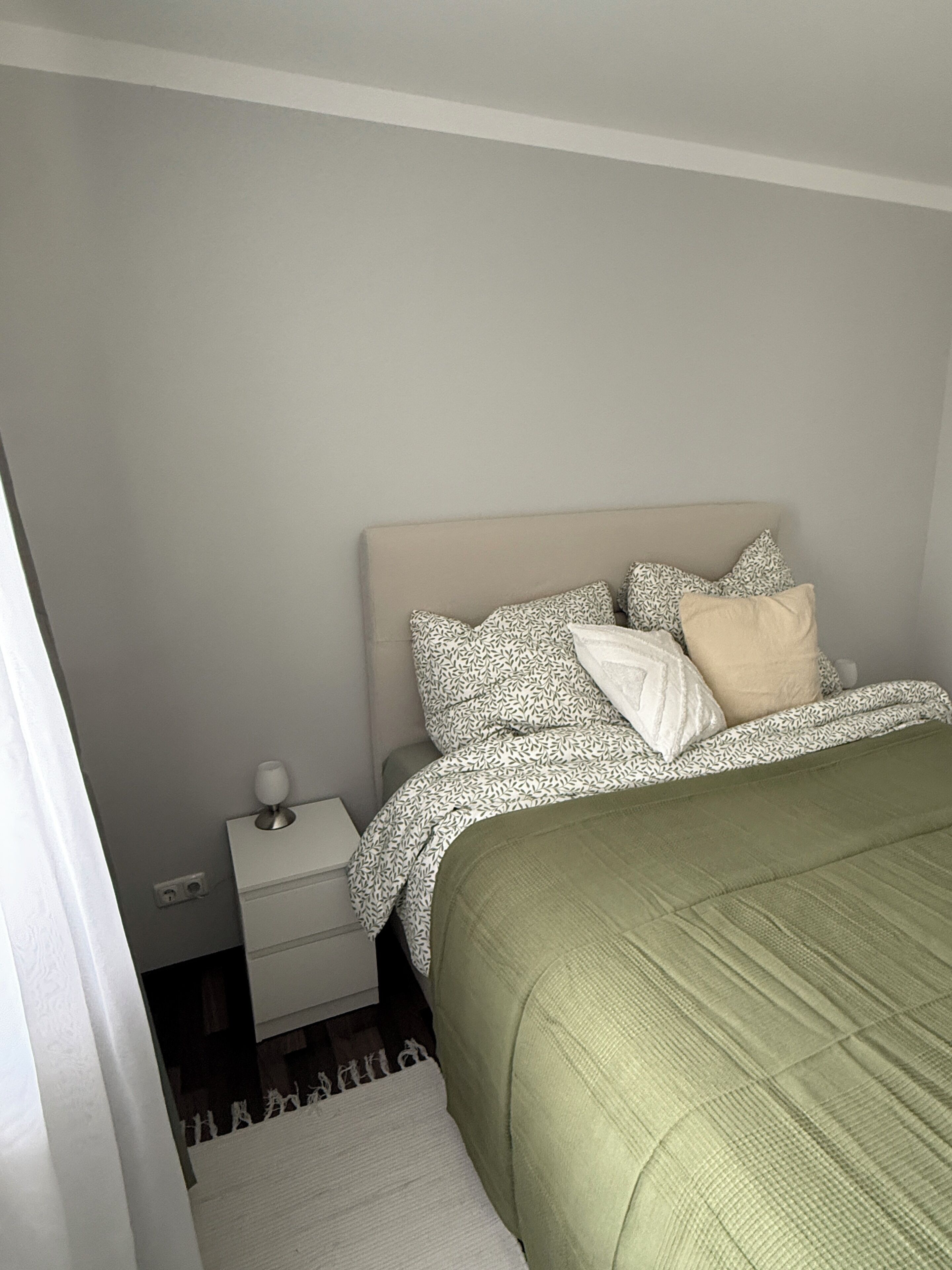 Une chambre à coucher avec un lit, une table de chevet et une commode.