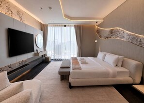 A modern hotel room with a large bed, a flat-screen TV, a seating area, and a view of the city. - 6BR Lamborghini Villa Cinema Spa & Pool (Dubai)