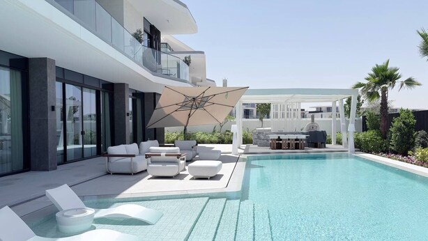A modern pool area with lounge chairs and a pergola. - 6BR Lamborghini Villa Cinema Spa & Pool (Dubai)