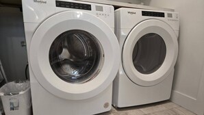 Zwei weiße Whirlpool Waschmaschinen in einem Waschraum mit Fliesenboden.