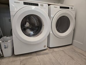Zwei weiße Whirlpool Waschmaschinen in einem Waschraum mit Fliesenboden.