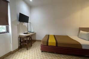 A hotel room with a bed, a desk with a flat-screen TV, and a window with blinds. - Cozy Single Stay Nr Mall Panakkukang W/ Free Wifi (Makassar)