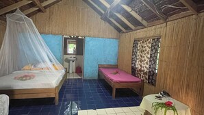 A room with two beds, a sink, and a window with curtains.