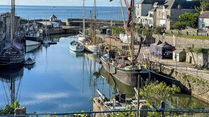 Un puerto con barcos, una grúa y edificios a lo largo de la costa.