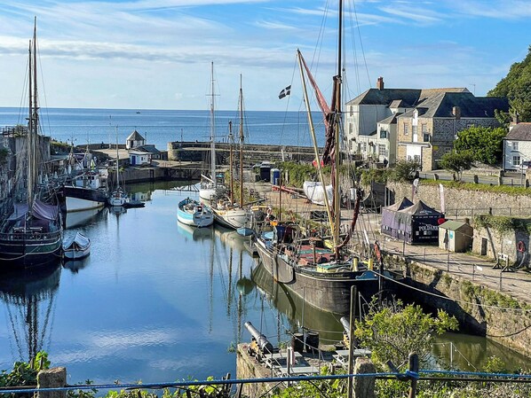A harbor with boats, a crane, and buildings along the waterfront.