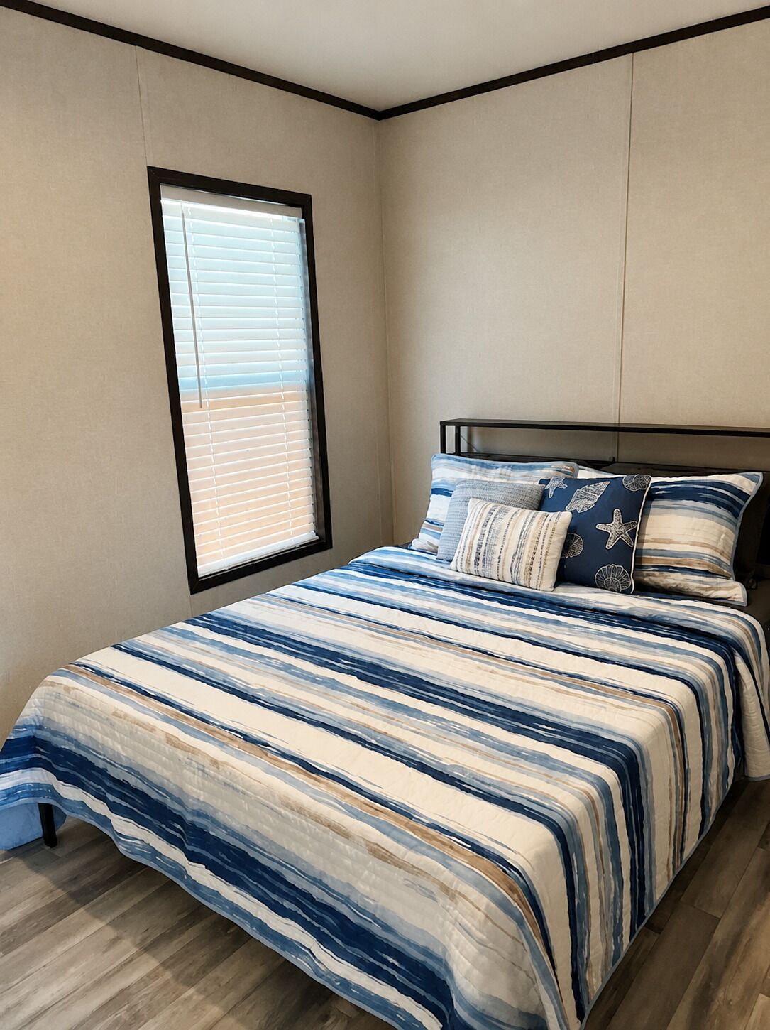A bedroom with a bed, a window, and a view of the outdoors.