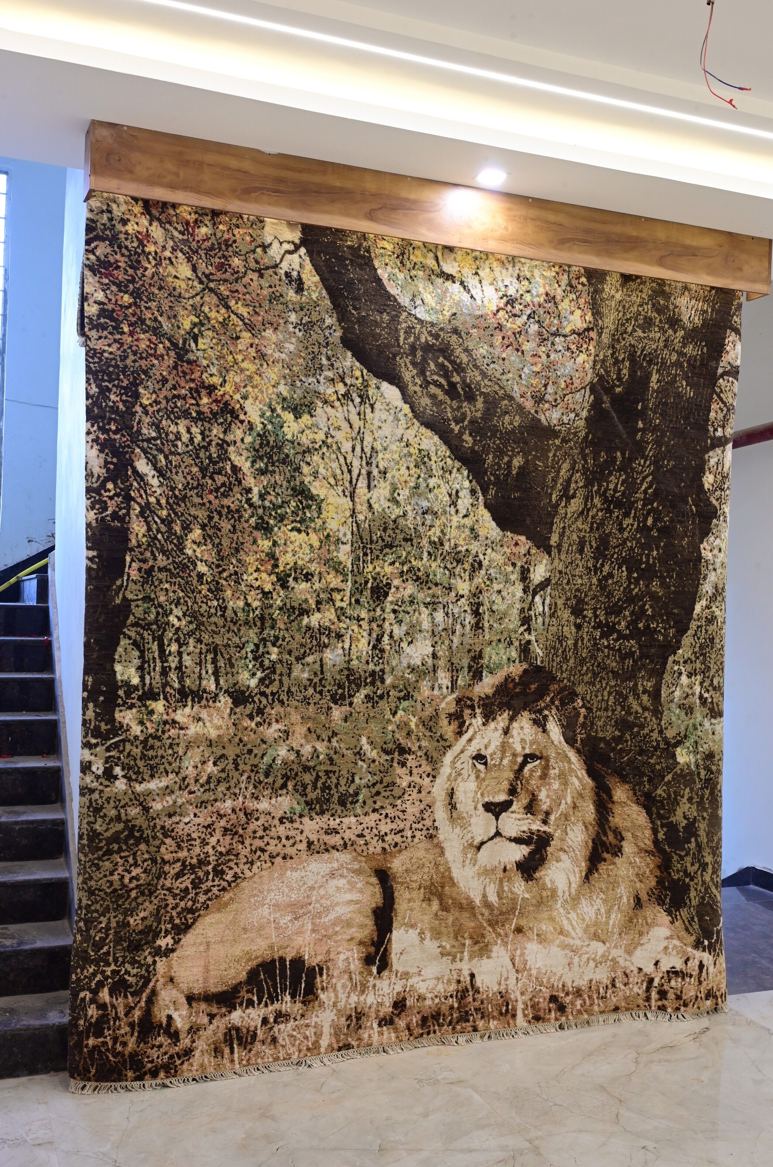 A large, detailed tapestry of a lion in a forest setting, displayed on a wall.