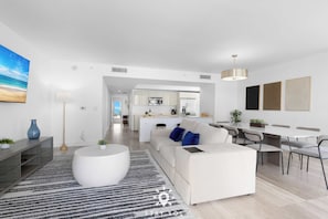 Ein modernes Wohnzimmer mit einer Couch, einem Couchtisch und einem Essbereich.