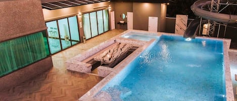 A rooftop pool area with a clear view of the hotel name 'SKYBEACH PoolVilla' and a slide.