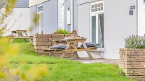 Ett hus med en stenmur, en träbänk och en liten trädgårdsyta.