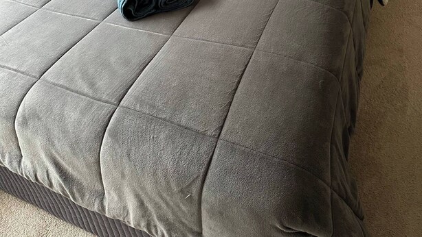 A neatly made bed with a grey quilt, a grey headboard, and two white pillows. - Cozy Curtin- 3 guests house (Curtin)