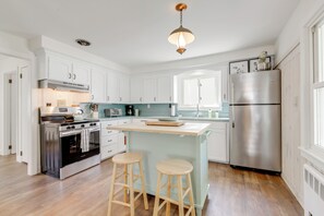 A modern kitchen with white cabinets, stainless steel appliances, and a central island with stools. - < 1 Mi to Dtwn Westerly! Walkable Coastal Escape (Westerly)