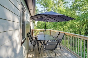 A wooden deck with a table and chairs, an umbrella, and a railing. - 'The Beautiful Home' 1/2 Mi to Old Hickory Lake! (Mt. Juliet)