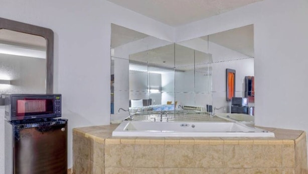 A bathroom with a large mirror, a bathtub, and a microwave. - 2 Full Beds|Nsmk|Kitchen (Little Rock AR)