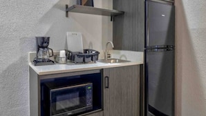 A compact kitchenette with a microwave, coffee maker, and a refrigerator. - 2 Full Beds|Nsmk|Kitchen (Little Rock AR)