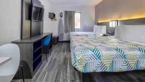 Ein Hotelzimmer mit Bett, Schreibtisch, Stuhl, Fernseher und Fenster.
